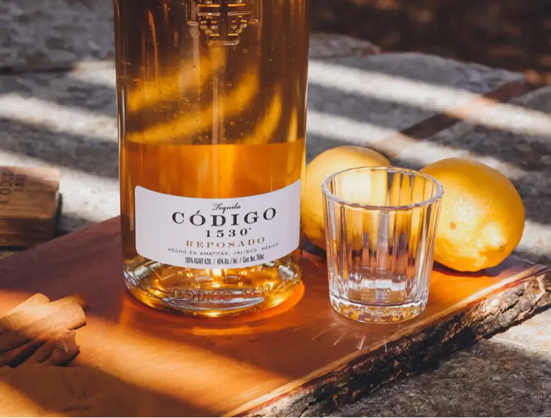 Codigo 1530 Reposado with tequila glass and lemons